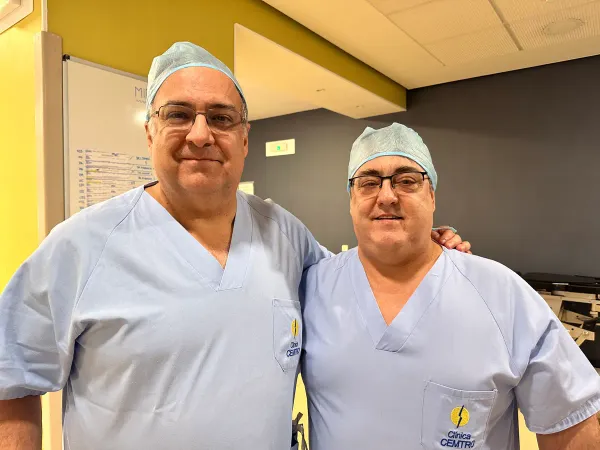 Dos cirujanos con ropa de quirófano de la Clínica CEMTRO, sonriendo en el área quirúrgica
