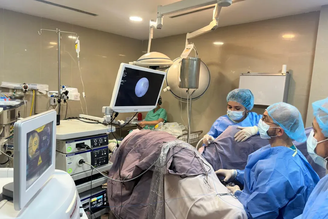 Equipo quirúrgico trabajando en quirófano, con torre de endoscopía y monitor en uso