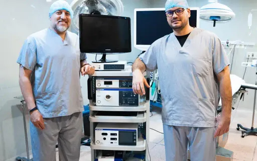 Dos médicos de la clínica junto a la torre de endoscopia Olympus en el quirófano